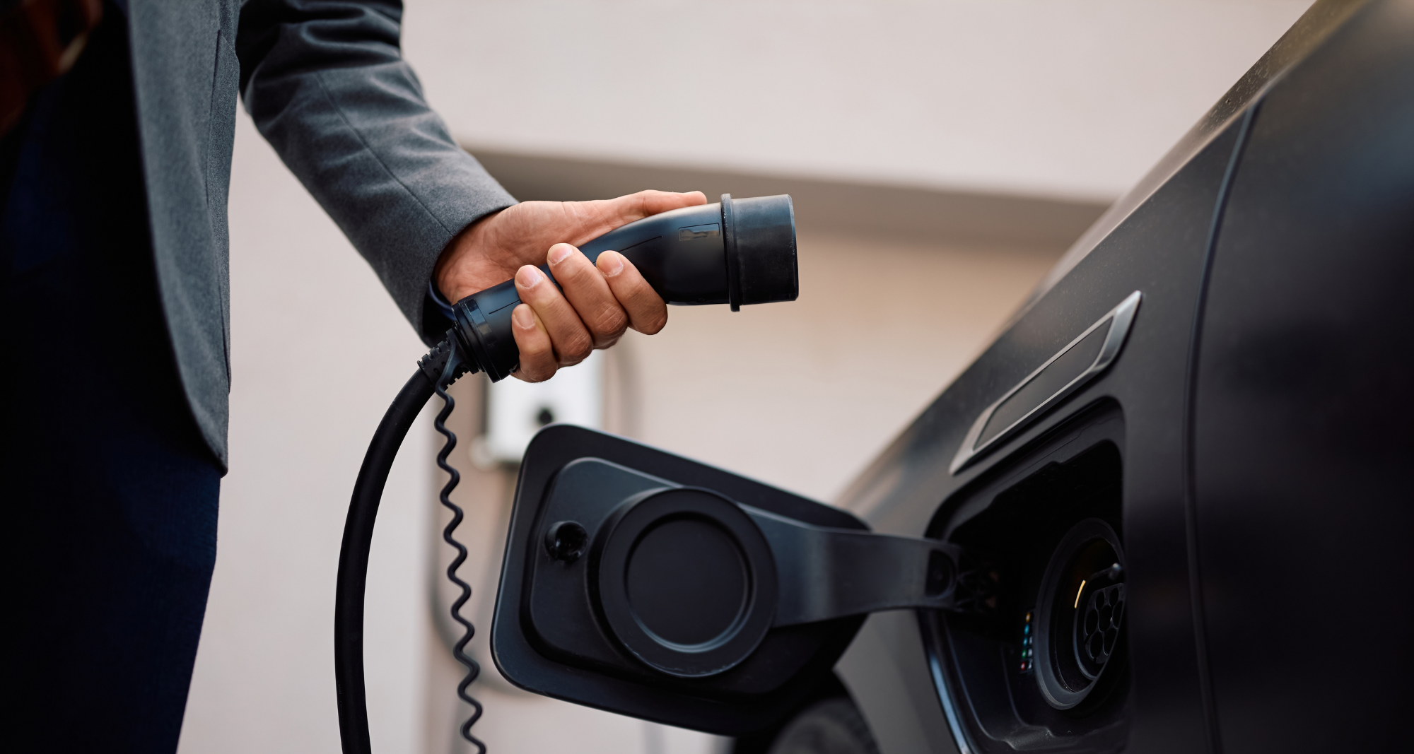 Gros plan sur un homme faisant la recharge de sa voiture hybride.
