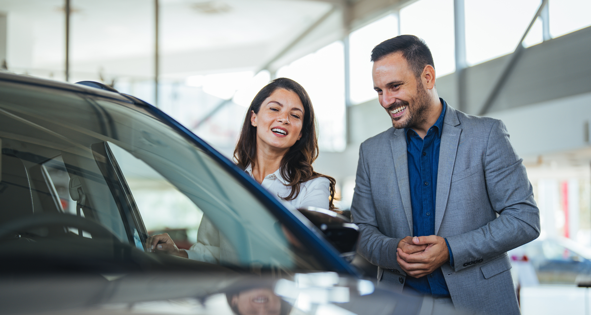 homme et femme regardant des voitures chez un concessionnaire de voitures. 